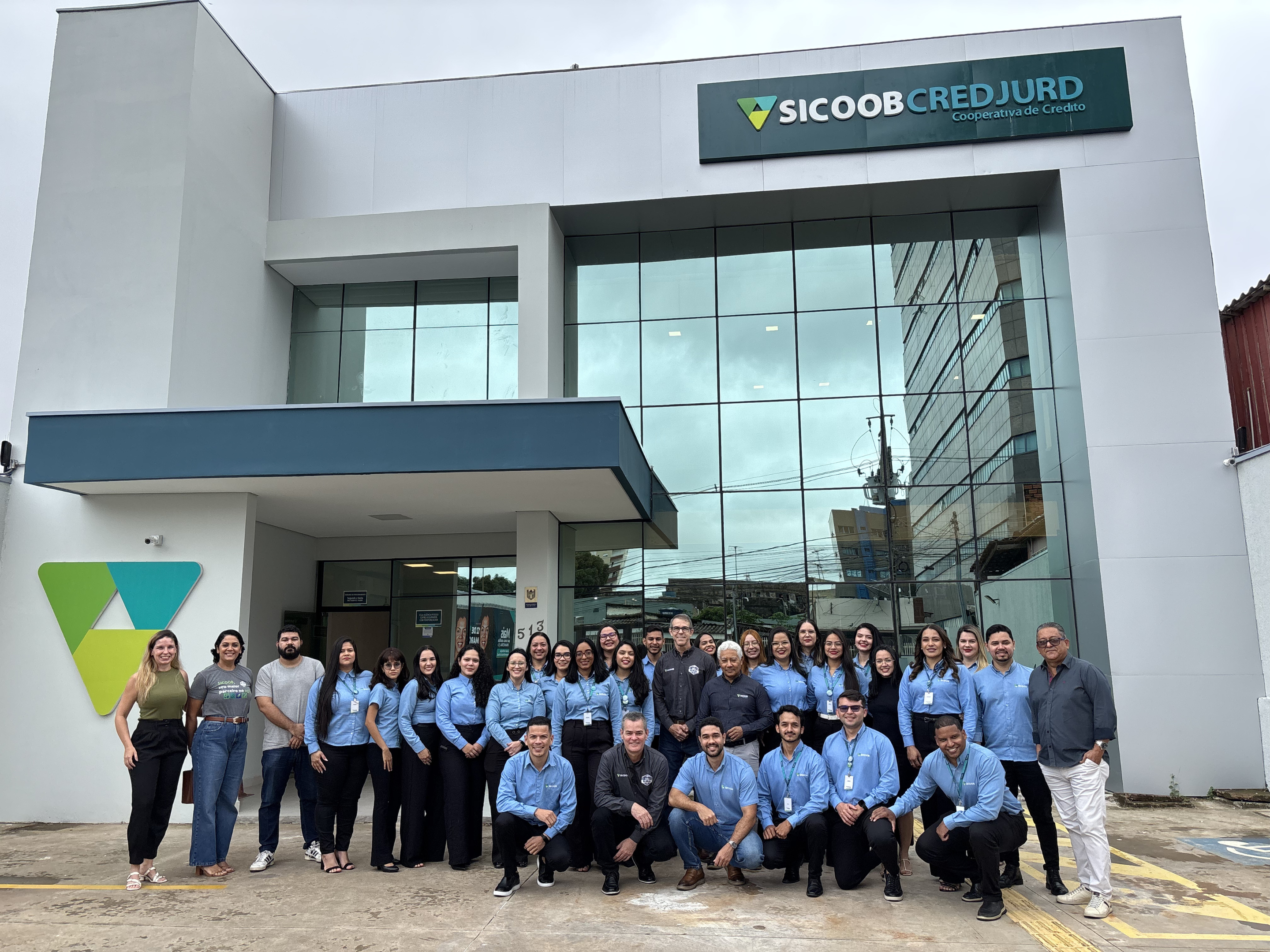Colaboradores celebrando a reinauguração da Agência Sede