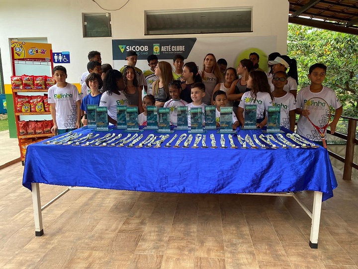 participantes do projeto diante da mesa de prêmios