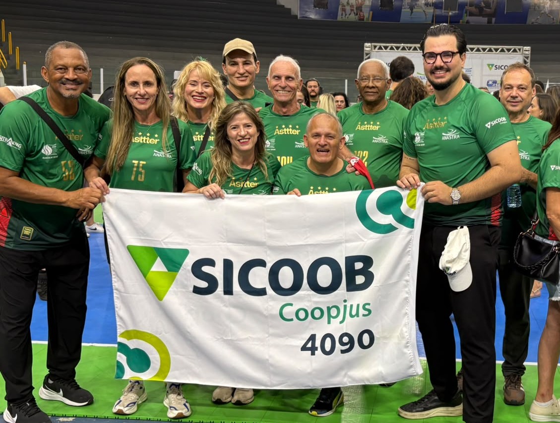 Gerente Samuel e atletas da Asttter segurando a bandeira do Sicoob Coopjus
