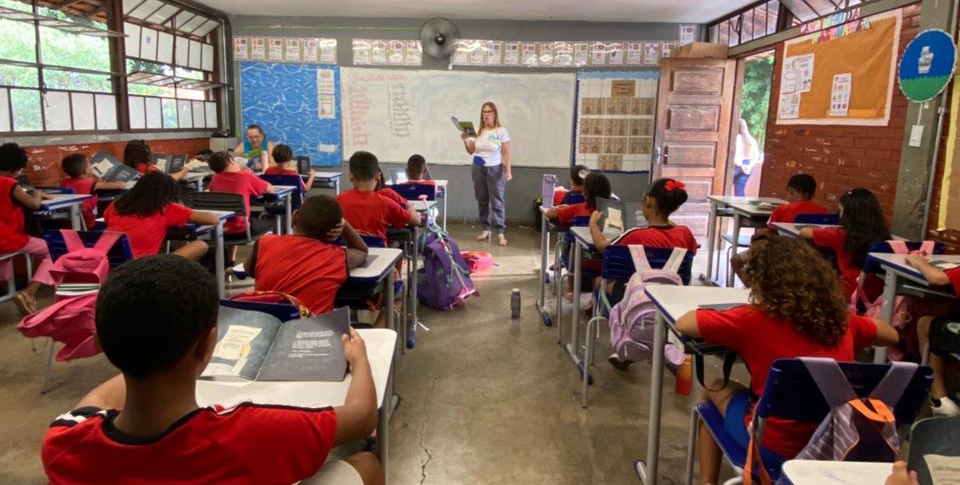 Alunos sentados em uma sala de aula, participando de uma contação de histórias.