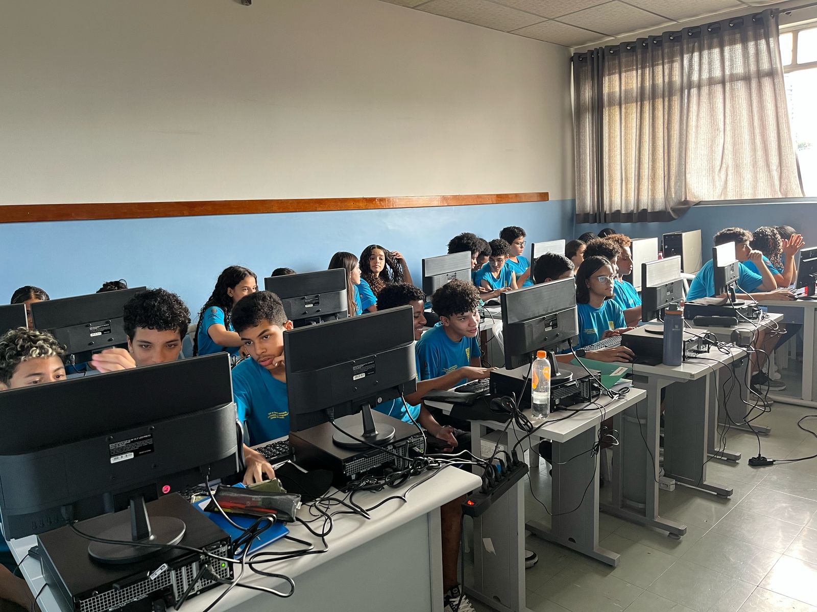 Adolescentes trabalhando em seus computadores. 