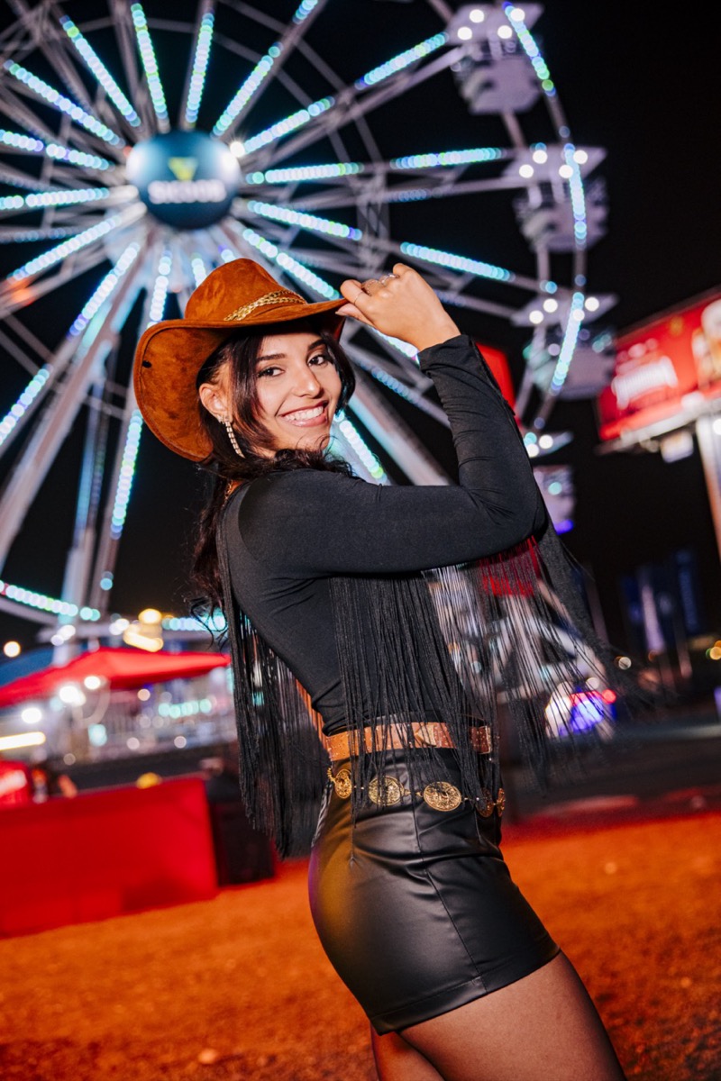 Cowgirl na frente da roda-gigante Sicoob no Jaguariúna Rodeo Festival